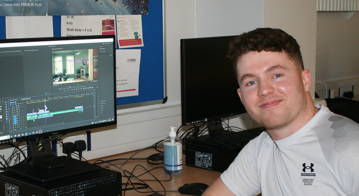 Student Mark Ellis in front of his computer screen showing his digital media project